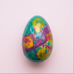 Load image into Gallery viewer, colourful painted milk chocolate egg on light pink background
