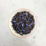 Load image into Gallery viewer, Tea leaves with cornflowers petals in a white bowl on a marble surface
