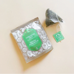 Load image into Gallery viewer, Sloane Marrakesh mint tea pouch beside its package on a beige  background
