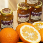 Load image into Gallery viewer, A 125ml jar of Yummies in a Jar marmalade with oranges on a wooden surface
