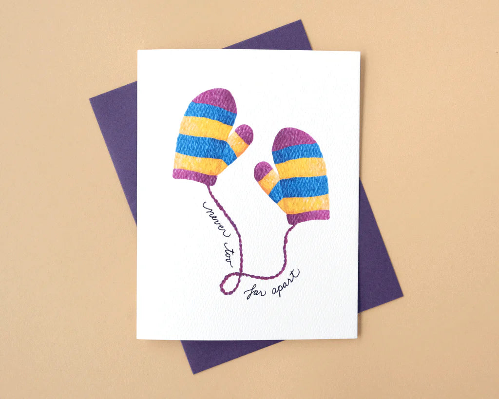Greeting card with colorful striped mittens on a beige background
