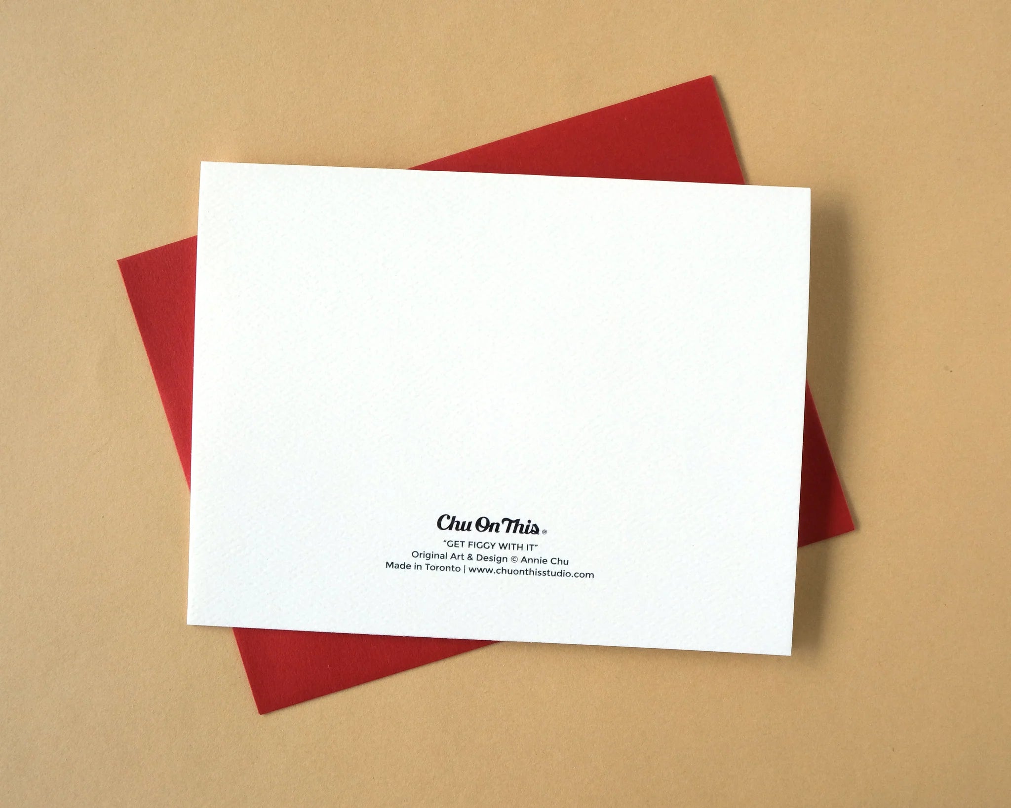 White card back with text on a red envelope against a beige background