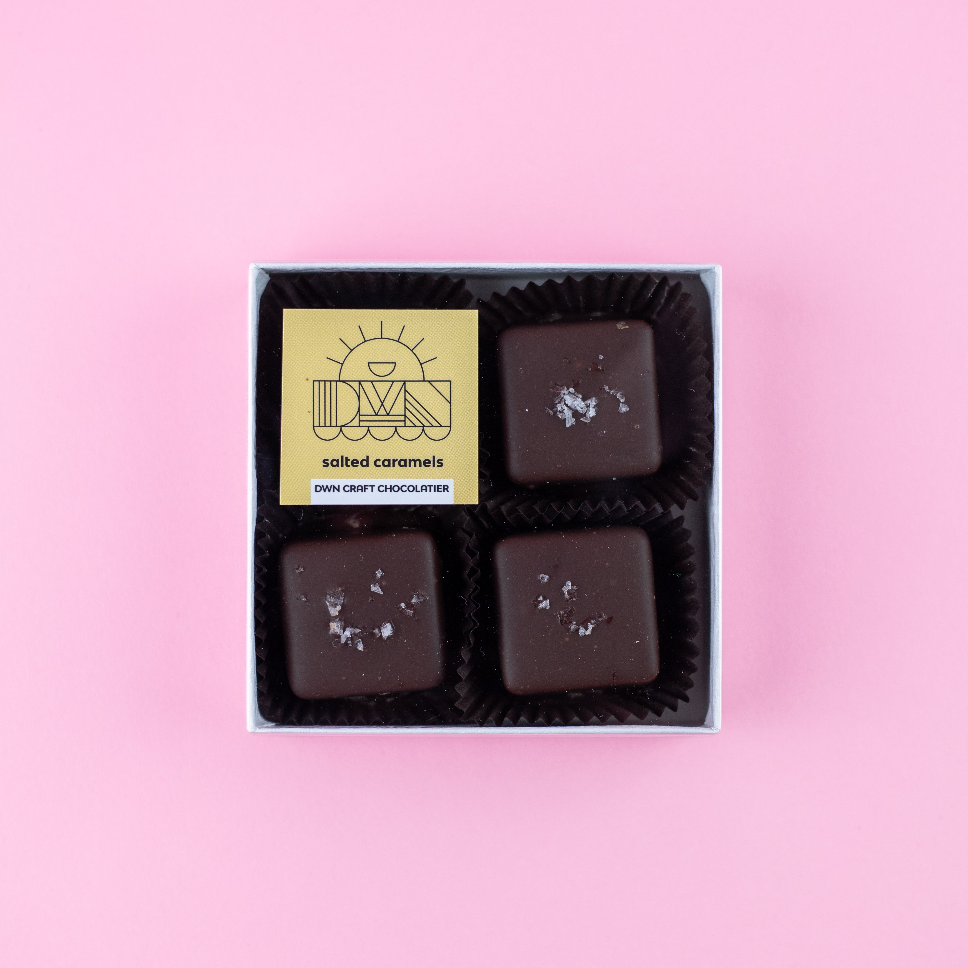 box of dark chocolate salted caramels with a DWN Chocolate label on a pink background