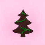 Load image into Gallery viewer, dark chocolate tree with green and red sprinkles on a pink background
