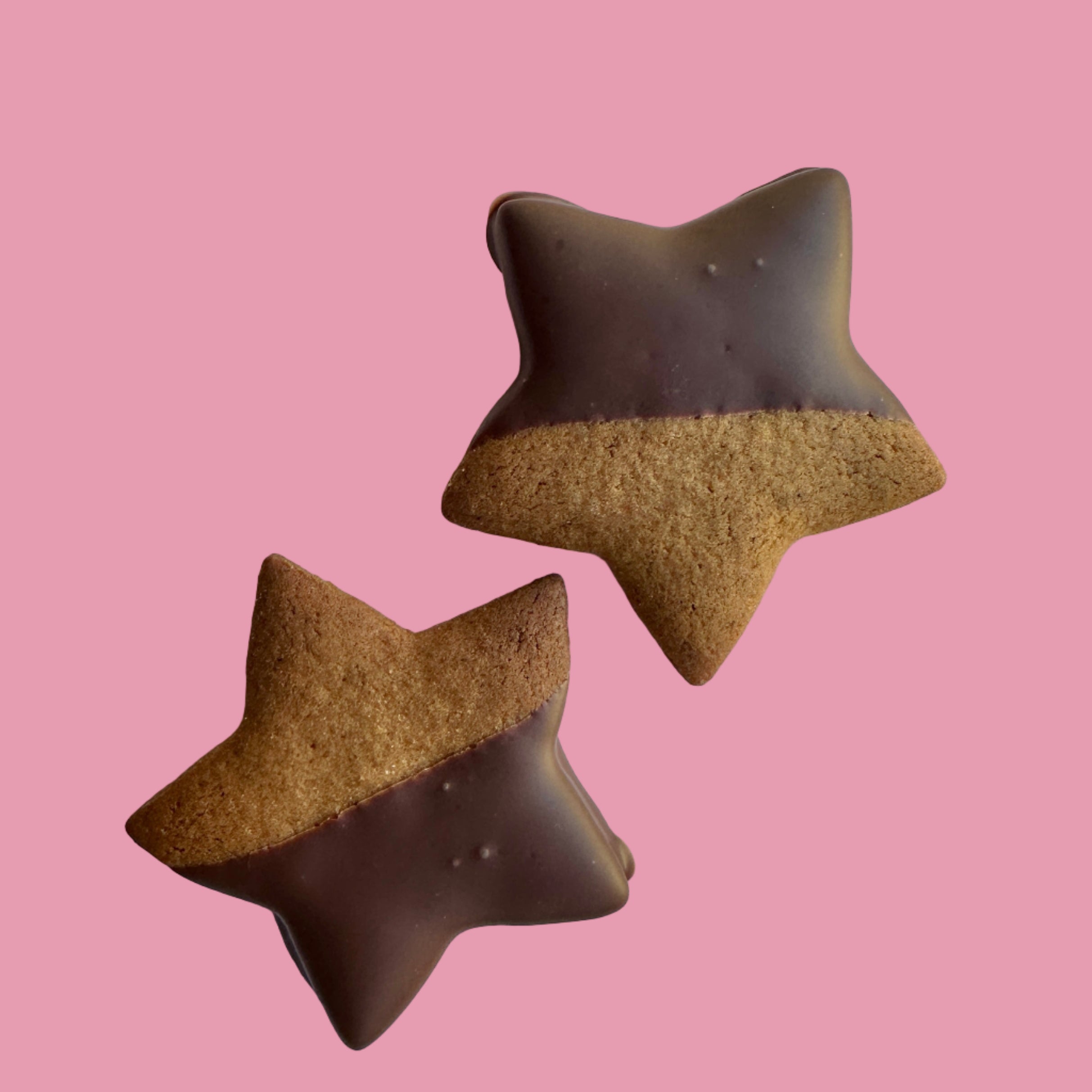two gingerbread stars dipped in chocolate