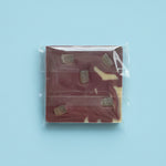 Load image into Gallery viewer, packaged haskap lemon chocolate bar with on a light blue background
