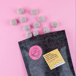 Load image into Gallery viewer, DWN pouch with macadamia nuts falling out a pink background
