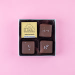 Load image into Gallery viewer, box of milk chocolate salted caramels with a DWN Chocolate label on a pink background
