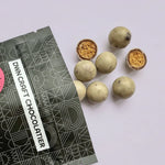 Load image into Gallery viewer, mocha cookie crunch malt balls falling out of a black DWN pouch
