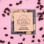 Load image into Gallery viewer, Packaged mocha latte mylk chocolate with a pink background and scattered coffee beans
