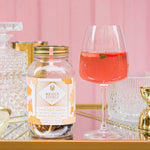 Load image into Gallery viewer, peach berry sangria cocktail infusion kit with a glass half way with the cocktail
