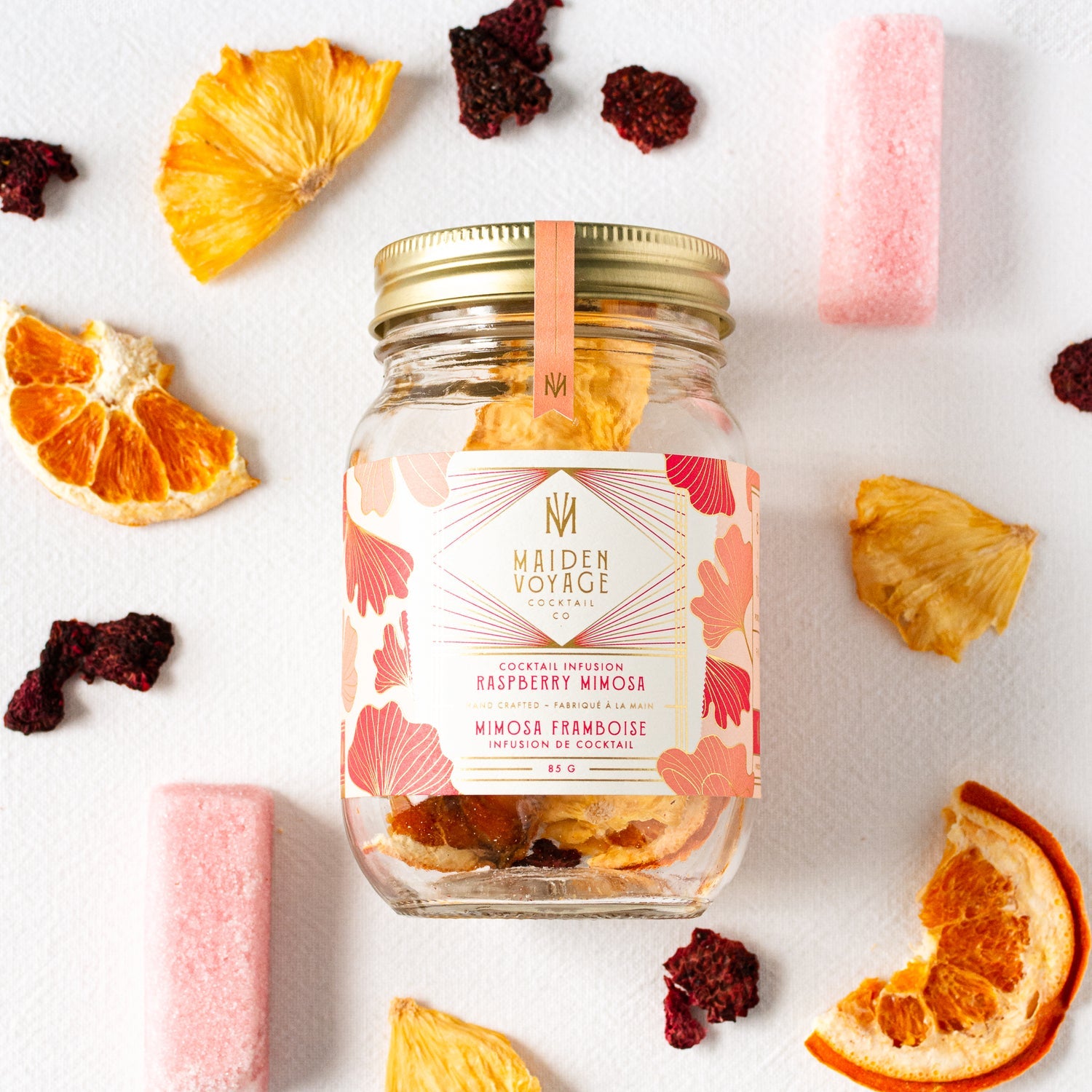 raspberry mimosa cocktail infusion kit jar among slices of dried oranges and pineapple