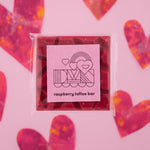 Load image into Gallery viewer, raspberry toffee bar packaging with heart designs on a pink background
