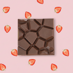 Load image into Gallery viewer, strawberry aperitif chocolate bar on a pink background with strawberry slices
