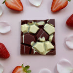 Load image into Gallery viewer, strawberry rose blush bar on a pink background surrounded by sliced strawberries and rose petals
