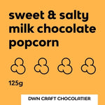 Load image into Gallery viewer, label for 'sweet &amp; salty milk chocolate popcorn' featuring a bright orange background, bold black text, and four outlined popcorn kernels 
