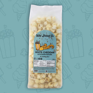 Bag of white cheddar kettle corn with a visible label on a teal background with popcorn icons.
