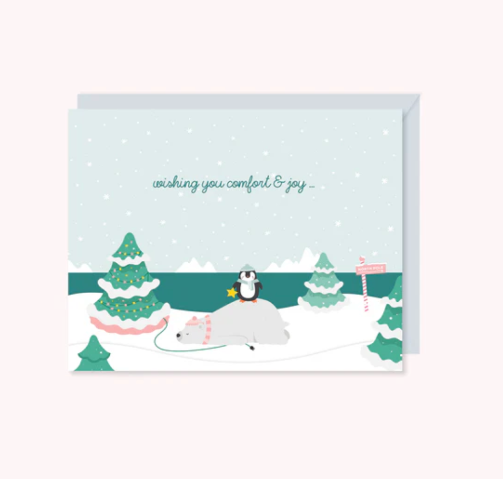 arctic theme with a penguin on a polar bear with a message that reads wishing you comfort and joy