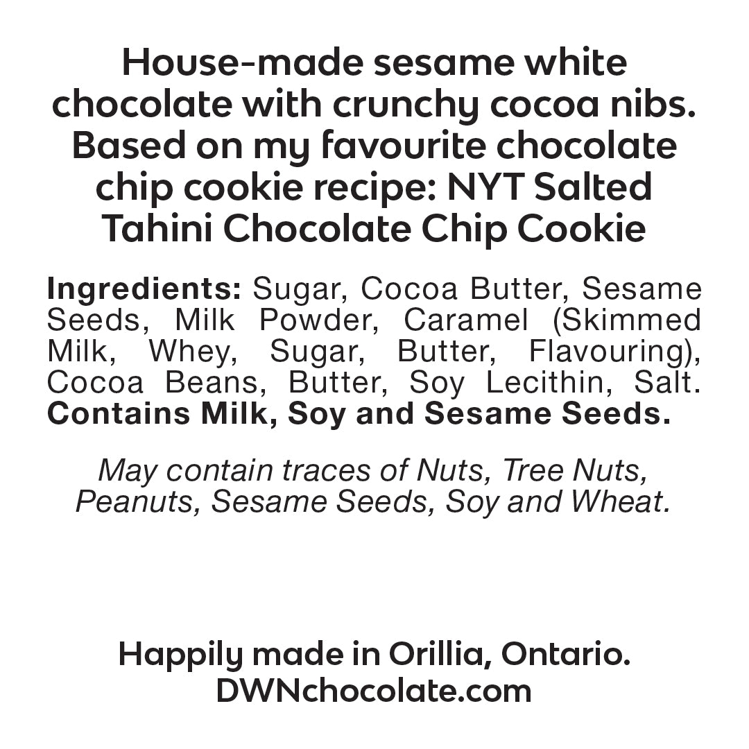 Sesame chocolate chip cookie bar ingredient label that reads, "house-made sesame white chocolate with crunchy cocoa nibs. Based on my favourite NYT salted tahini chocolate chip cookie recipe. Ingredients: Sugar, Cocoa Butter, Sesame Seeds, Milk Powder, Caramel (Skimmed Milk, Whey, Sugar, Butter, Flavouring), Cocoa Beans, Butter, Soy Lecithin, Salt. Contains Milk, Soy and Sesame Seeds.  May contain traces of Nuts, Tree Nuts, Peanuts, Sesame Seeds and Wheat. Happily made in Orillia, Ontario. DWNchocolate.com"