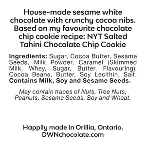 Sesame chocolate chip cookie bar ingredient label that reads, "house-made sesame white chocolate with crunchy cocoa nibs. Based on my favourite NYT salted tahini chocolate chip cookie recipe. Ingredients: Sugar, Cocoa Butter, Sesame Seeds, Milk Powder, Caramel (Skimmed Milk, Whey, Sugar, Butter, Flavouring), Cocoa Beans, Butter, Soy Lecithin, Salt. Contains Milk, Soy and Sesame Seeds.  May contain traces of Nuts, Tree Nuts, Peanuts, Sesame Seeds and Wheat. Happily made in Orillia, Ontario. DWNchocolate.com"