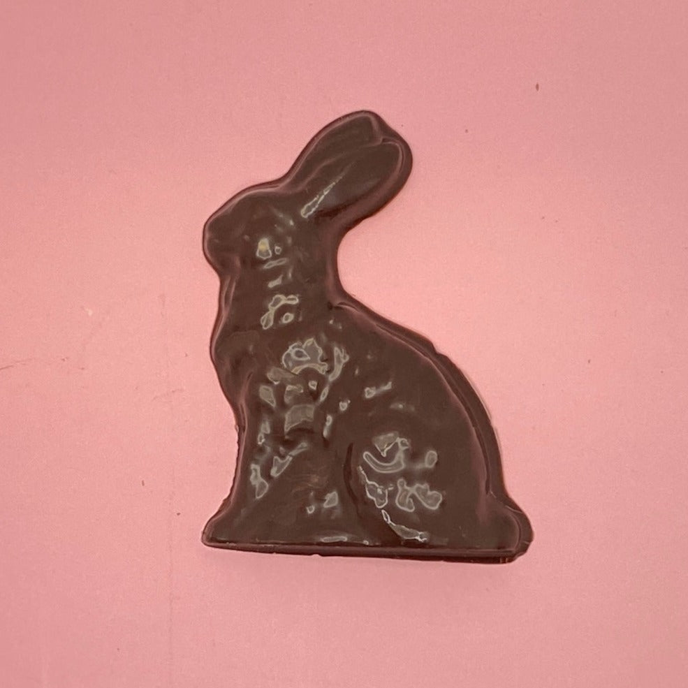 dark chocolate rabbit on a pink background