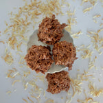 Load image into Gallery viewer, four coconut clusters sit on a white background with toasted coconut scattered around
