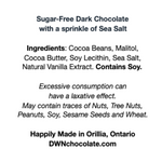 Load image into Gallery viewer, white ingredient label with black text that reads, &quot;Sugar-Free Dark Chocolate with a sprinkle of Sea Salt Ingredients: Cocoa Beans, Malitol,  Cocoa Butter, Soy Lecithin, Sea Salt,  Natural Vanilla Extract. Contains Soy. Excessive consumption can  have a laxative effect. May contain traces of Nuts, Tree Nuts,  Peanuts, Soy, Sesame Seeds and Wheat. Happily Made in Orillia, Ontario DWNchocolate.com&quot;
