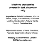 Load image into Gallery viewer, black text on a white background that reads, &quot;Muskoka cranberries  covered in dark chocolate 100g  Ingredients: Dried Cranberries, Cocoa  Beans, Sugar, Cocoa Butter, Sunflower  Lecithin, Soy Lecithin, Natural Vanilla  Extract. Contains Soy.     May contain traces of Nuts, Tree Nuts,  Peanuts, Sesame Seeds and Wheat.    Happily Made in Orillia, Ontario DWNchocolate.com&quot;
