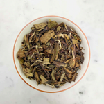 Load image into Gallery viewer, an overhead shot of the tea leaves in a bowl on a marble background
