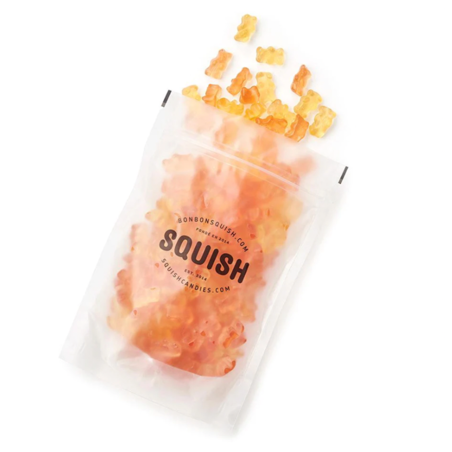 a bag of sparkling bear gummies lies on a white background with the gummies falling out of the pouch